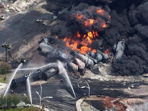 Smoke rises from railway cars that were carrying crude oil after derailing in Lac-Megantic, Que., July 6, 2013. A Quebec Superior Court judge has found Canadian Pacific Railway not liable in the 2013 Lac-Megantic tragedy.