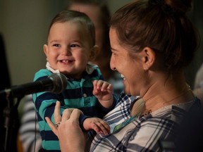 Mother Courtney Sastaunik holds her child while discussing children's baby formula shortages on Thursday.
