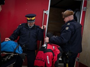 Melfort Royal Canadian Mounted Police Staff Sgt. Darren Simons, right, and Staff Sgt. Dwayne Whitford from the Saskatchewan RCMP's North District Management Team unload donated bags of hockey gear from a truck in James Smith Cree Nation, Sask., in an undated handout photo.