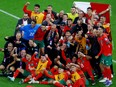 Morocco players and staff pose for a photo after the match as Morocco progress to the semi finals.