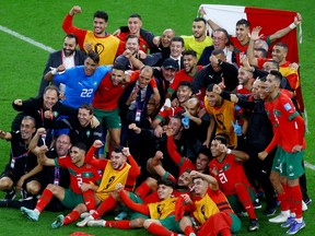 Morocco players and staff pose for a photo after the match as Morocco progress to the semi finals.