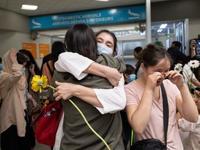 Marefat High School students embrace each other on Aug. 27, after being reunited with their former classmates at the Saskatoon International Airport one year after the Taliban took control of Kabul, Afghanistan.