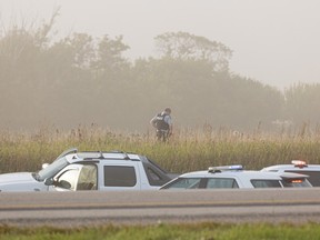 A police officer takes a moment in a field at the scene of Myles Sanderson’s arrest on Sept. 6, after a stabbing spree on James Smith Cree Nation, on Highway 11 North of Saskatoon.