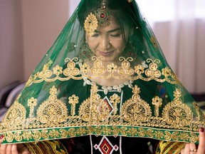 Rejna Ahmadi puts on a scarf that was sent to her from her fiancée M. Jawid Shoja on May 17. It symbolizes leaving her parents to live with him. Green is for luck and fortune; gold is for shining and representing the bride’s value.