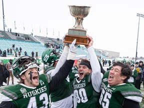 (From left) U of S Huskies’ Nick Wiebe, Caleb Morin and Michael Palumbo hoist up the Hardy Cup after defeating the UBC Thunderbirds 23-8 in the Canada West football final at Griffiths Stadium on Nov. 2.