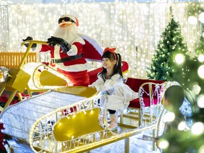 Emily Zhou rides on Santa's sleigh at Glow Saskatoon at Prairieland Park.