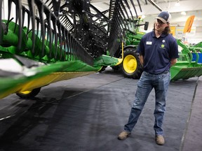 Tyson Miazga shows off the John Deere X9 1000 combine with an HD45R header at the Western Canadian Crop Production Show at Praireland Park's World Trade Centre. Photo taken in Saskatoon, Sask. on Monday, Jan. 9, 2022.