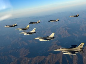 In this handout image released by the South Korean Defense Ministry, South Korean Air Force F-35 fighter jets and U.S. Air Force F-16 fighter jets fly over South Korea during joint air drills on November 18, 2022 at an undisclosed location in South Korea.