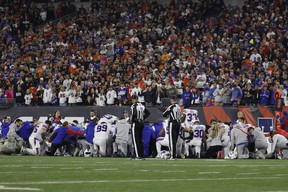 Buffalo Bills players huddle and pray after teammate Damar Hamlin #3 was injured against the Cincinnati Bengals during the first quarter at Paycor Stadium on January 02, 2023 in Cincinnati, Ohio.