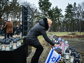A woman lights a candle at the Ruins of gas chamber and crematorium IV in the former Nazi-German concentration and extermination camp KL Auschwitz II-Birkenau during the 78th Anniversary of Auschwitz Liberation on Jan. 27, 2023 in Oswiecim, Poland.
