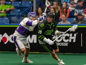 Saskatchewan Rush forward Ryan Keenan in action against Brooker Muir of Panther City during a National Lacrosse League game in December 2022.