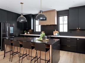 Pure Developments is sparking conversation with its new show home at 338 Taube Green in Brighton. The builder has made daring use of black design elements, particularly in the stunning kitchen which features black painted cabinetry, against a black vertical subway tile backsplash. The range hood and island pop against the black backdrop, crafted from butterscotch-toned rift-cut oak.