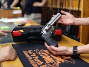 A co-owner of That Hunting Store shows a customer a Ruger GP100 Magnum 357 on June 3, 2022 in Ottawa, Canada.