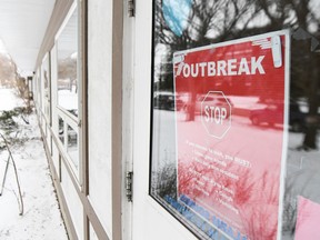 An outbreak warning is posted to a door at Parkside Extendicare in Regina (file).