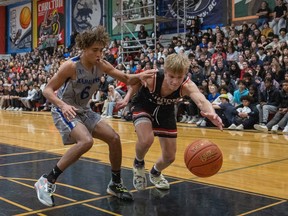 The Raymond Comets' Everson Harker lunges for the ball in close quarters with Walter Murray Marauders' Datiel Fountaine during the final of Saturday's Bedford Road Invitational Tournament. Photo by Victor Pankratz