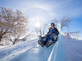 Ray and Lou Kaufhold take a ride down the ice slide at the Nutrien Winter Shines festival site. Environment Canada expects overnight low temperatures to be in the -30s this week, before warming up for the weekend. Photo taken in Saskatoon, Feb. 21, 2023.