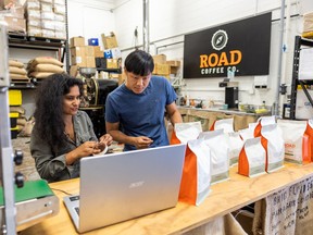 Alisha Esmail, left, and Tao Zhou label coffee in Road Coffee’s studio at the Saskatoon Makerspace, a non-profit community workspace in Riversdale.