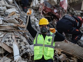 A rescuer communicates with colleagues during an operation to search for bodies of victims under the rubble of a collapsed building in Antakya on Feb. 18, 2023.