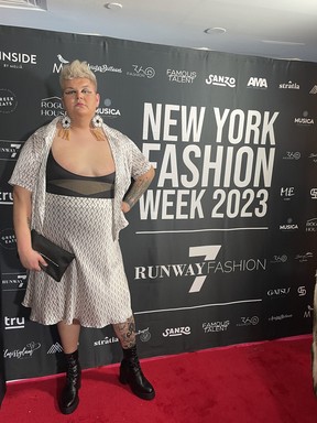 Jazz Moise poses in front of a banner at New York Fashion Week.
