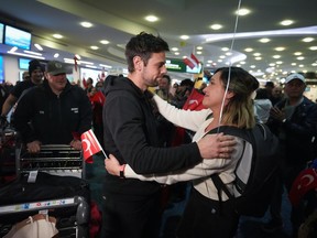 A woman embraces a member of the Burnaby Urban Search and Rescue Team as they are greeted by members of the Turkish Canadian community upon arrival from Turkey at Vancouver International Airport, in Richmond, B.C., on Tuesday, February 14, 2023. The team of volunteer search and rescue experts, which is mostly comprised of firefighters from Burnaby, deployed to Turkey the day after last week's 7.8 magnitude earthquake.