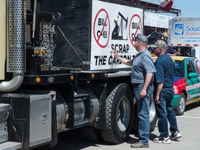 Visitors to the Saskatchewan Oil & Gas Show held at the Crescent Pointe Centre in Weyburn sign an snti-carbon tax sign on a semi truck. BRANDON HARDER/ Regina Leader-Post