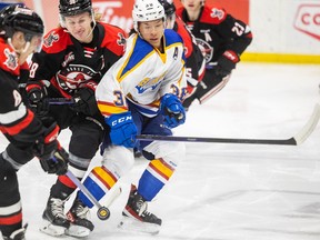 Saskatoon Blades centre Trevor Wong (38) battles with Moose Jaw Warriors centre Ryder Korczak (38) and Moose Jaw Warriors forward Eric Alarie (8) for the puck during WHL action in a game in January.