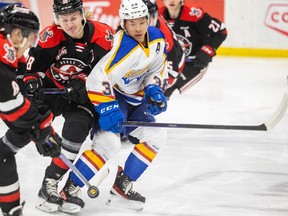 Saskatoon Blades centre Trevor Wong (38) battles with Moose Jaw Warriors centre Ryder Korczak (38) and Moose Jaw Warriors forward Eric Alarie (8) for the puck during WHL action in Saskatoon on Wednesday, January 18, 2023.