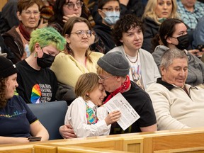 10-year-old Zipp Neufeld receives a hug after speaking to a city council committee meeting on March 8 regarding a request to change the policy on changeroom use at city facilities. The current policy allows people to use the changeroom corresponding to the gender they identify with.