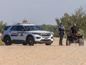 An RCMP officer talks with a resident on James Smith Cree Nation following the mass murder spree on James Smith Cree Nation, SK on Tuesday, September 6, 2022.