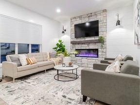 In the open concept living room a fireplace with tumbled stone surround, white shiplap and distressed wood mantle creates a stylish focal point and gathering place.