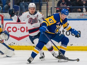 Saskatoon Blades defenceman Charlie Wright (47) skates as Regina Pats forward Connor Bedard (98) looks on during the first period of WHL playoff hockey action in Saskatoon, Sask., on Friday, March 31, 2023.