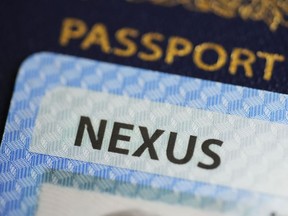 A NEXUS card and a Canadian passport are pictured in Ottawa on Tuesday, Jan. 17, 2023. The federal government says the Nexus trusted-traveller program will fully ramp back up within five weeks, allowing frequent border crossers to complete their applications and speed up their trips.