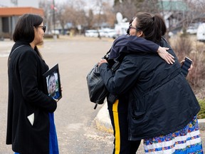 Deborah Burns holds a photo of Earl Burns and Vanessa Burns hugs Rhonda Blackmore, Commanding Officer of the Saskatchewan RCMP, after attending a presentation of the timeline of events that took place during the James Smith Cree Nation and Weldon stabbing rampage which left 11 victims dead and 17 injured.