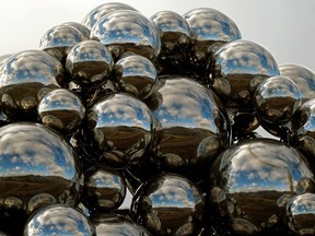 Blue sky and clouds are refelected off the silver balls of the Talus Dome art installation beside Whitemud Drive in southwest Edmonton on Thursday October 15, 2020.