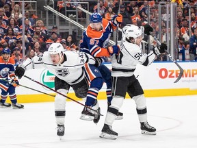 Los Angeles Kings' Arthur Kaliyev (34) and Sean Durzi (50) check Edmonton Oilers' Connor McDavid (97) during second period NHL Stanley Cup first round playoff action in Edmonton on Wednesday April 19, 2023.THE CANADIAN PRESS/Jason Franson