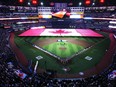 The Toronto Blue Jays and Detroit Tigers stand for the national anthem along with fans prior to the Blue Jays' home opener in MLB American League baseball action in Toronto on Tuesday, April 11, 2023.