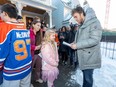 Cecily Eklund gives a card to Connor McDavid after he presented a new van to the Kids With Cancer Society on Wednesday, Dec. 14, 2022 in Edmonton. Cecily has a brain tumour.