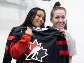 Canadian Olympic hockey player Jocelyne Larocque (right) autographed a jersey for Nivaeh Bear during the Girls and Goals hockey panel at White Buffalo Youth Lodge in Saskatoon on May 19, 2023.