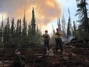 Firefighters work on one of the bulldozer control lines fighting a wildfire in the Northwest Territories in a recent handout photo. Officials in theN.W.T. say more than half of the wildfires in the territory this year were started by people.