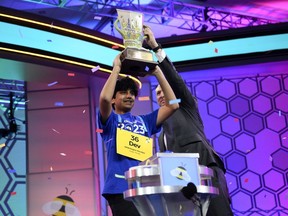 Dev Shah, 14, from Largo, Fla., lifts the trophy next to Scripps CEO Adam Symson after he won the Scripps National Spelling Bee finals, Thursday, June 1, 2023, in Oxon Hill, Md.