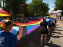 During the Saskatoon Pride Parade on June 18, 2022 in Saskatoon, members of the RBC Parade Troop carried a large rainbow flag through downtown Saskatoon.