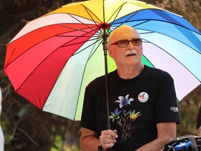 Peter Lippmann, standing under a grand Pride umbrella, was among those who gathered for the Saskatoon Pride opening ceremony at Civic Plaza in downtown Saskatoon.