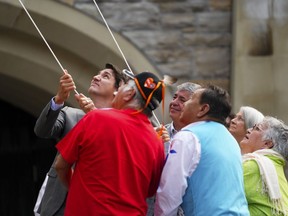 Prime Minister Justin Trudeau joins residential school survivors, left to right, Frank Cote, Andrew Carrier, Laurie McDonald and Navalik Tologanak as they raise the Survivors' Flag during a commemorative ceremony, Raising the Survivors' Flag, on Parliament Hill in Ottawa on Wednesday, June 21, 2023. Governor General Mary Simon looks on at back right. The ceremony is "in memory of the thousands of children who were sent to residential schools, of those who never returned, and in honour of the families whose lives were forever changed."