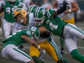 Edmonton Elks quarterback Taylor Cornelius (15) gets tackled by the Saskatchewan Roughriders during the first half of CFL action at Mosaic Stadium on Thursday, July 6, 2023 in Regina.