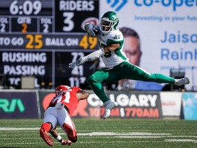 Saskatchewan Roughriders running back Jamal Morrow, right, leaps away from Calgary Stampeders defensive back Tre Roberson during first half CFL football action in Calgary, Alta., Saturday, June 24, 2023.