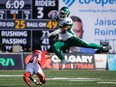Saskatchewan Roughriders running back Jamal Morrow, right, leaps away from Calgary Stampeders defensive back Tre Roberson during first half CFL football action in Calgary, Alta., Saturday, June 24, 2023.