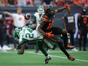 B.C. Lions' Dominique Rhymes (19) fails to make the reception as he's hit by Saskatchewan Roughriders' Deontai Williams (24) during the first half of a CFL football game, in Vancouver, on Saturday, July 22, 2023.