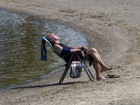 Duane relaxes on the banks of the Ottawa River in Ottawa on Tuesday, July 4, 2023. Several parts of Canada continue to swelter under intense heat, prompting weather warnings.
