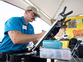 Gabriel works on a caricature at Quick Draw Caricatures at the Saskatoon EX. Photo taken in Saskatoon, Sask. on Tuesday, August 8, 2023.