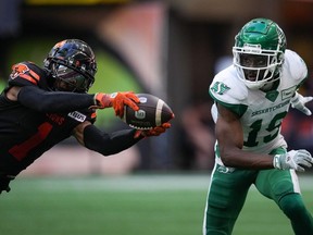 B.C. Lions' Garry Peters, left, intercepts a pass intended for Saskatchewan Roughriders' Samuel Emilus (19) during the second half of a CFL football game, in Vancouver, on Saturday, July 22, 2023.